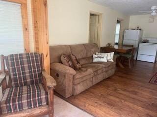 living room featuring ceiling fan, wood-type flooring, and washer / dryer