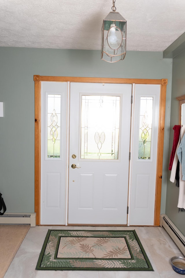 foyer with a textured ceiling, a healthy amount of sunlight, and a baseboard heating unit