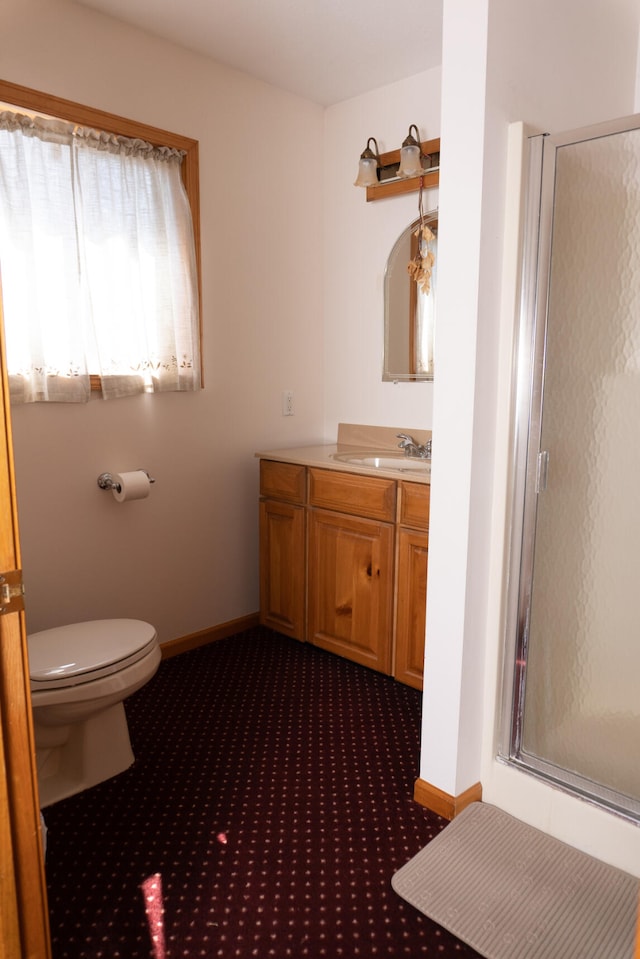 bathroom with toilet, a shower with shower door, and vanity