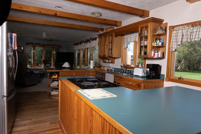 kitchen featuring hardwood / wood-style flooring, ceiling fan, beamed ceiling, black gas cooktop, and sink