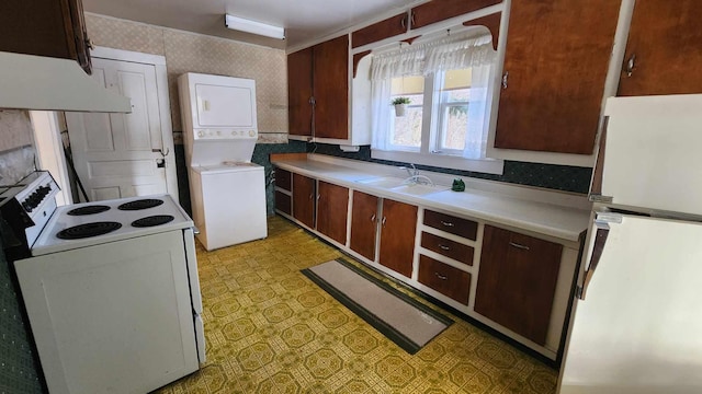 kitchen with refrigerator, white electric stove, stacked washer and dryer, custom range hood, and light tile floors