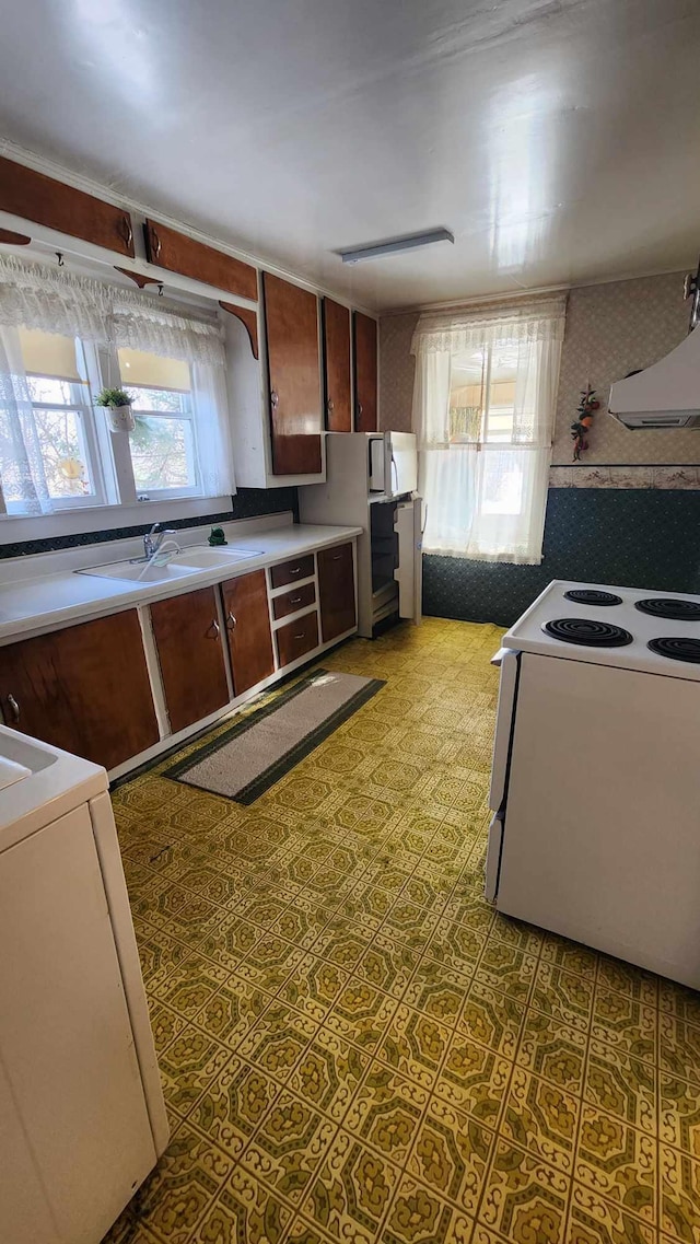 kitchen with plenty of natural light, sink, white electric range oven, and wall chimney range hood