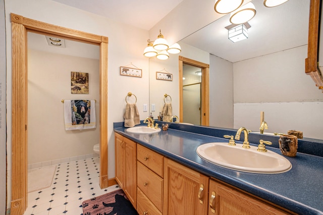 bathroom with double sink, oversized vanity, toilet, and tile floors