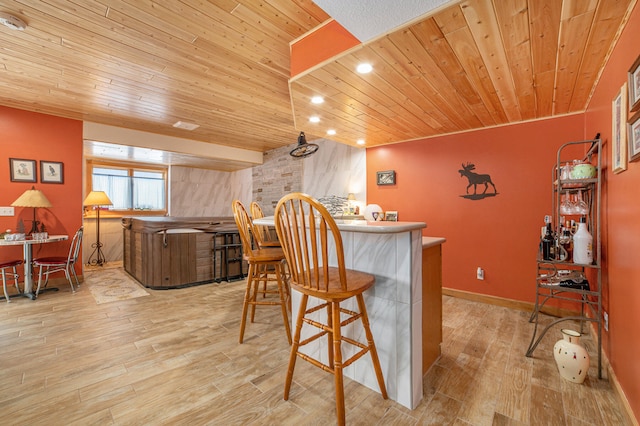 dining room with wooden ceiling, indoor bar, and light wood-type flooring