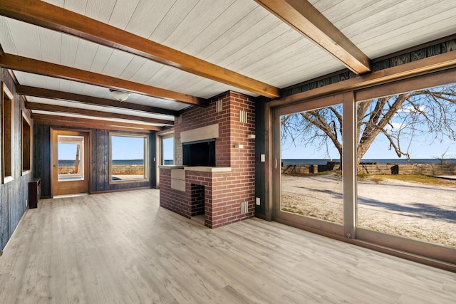 interior space with beamed ceiling, light wood-type flooring, and wooden walls