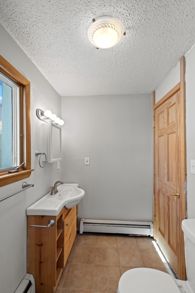 bathroom featuring vanity, a baseboard radiator, a textured ceiling, and toilet