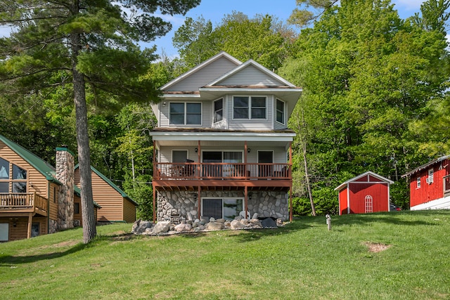 rear view of property featuring a shed and a lawn