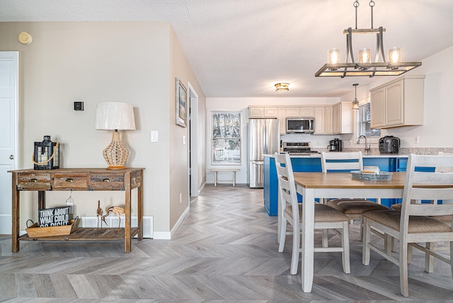 dining area with a notable chandelier, a textured ceiling, and light parquet flooring