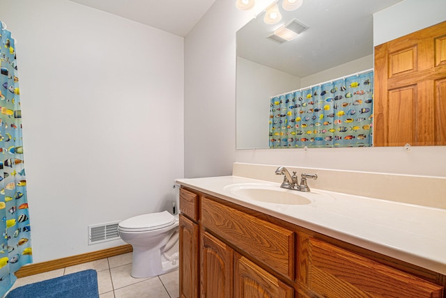 bathroom featuring tile flooring, vanity, and toilet