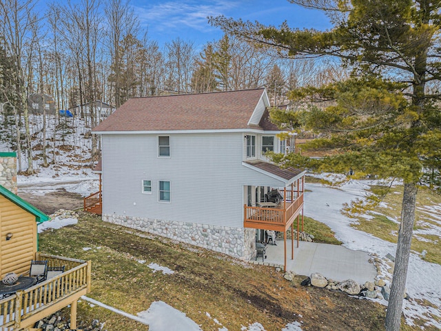 view of snowy exterior with a wooden deck