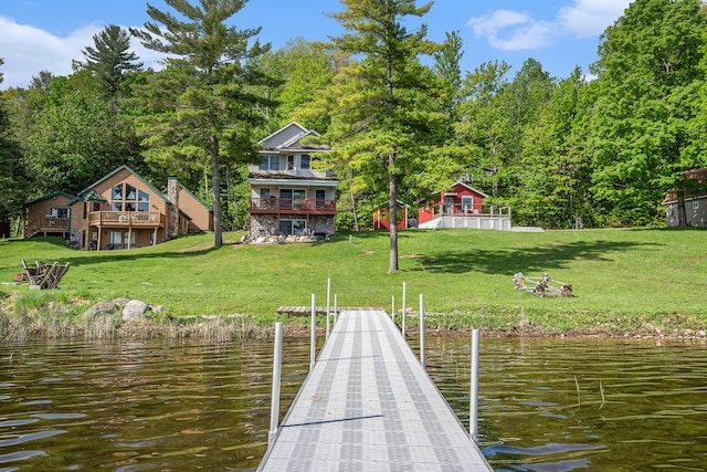 view of dock featuring a deck with water view and a yard