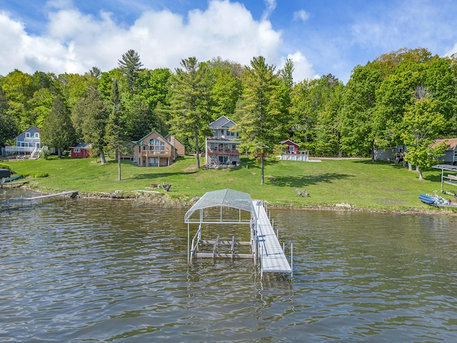 view of dock with a lawn and a water view