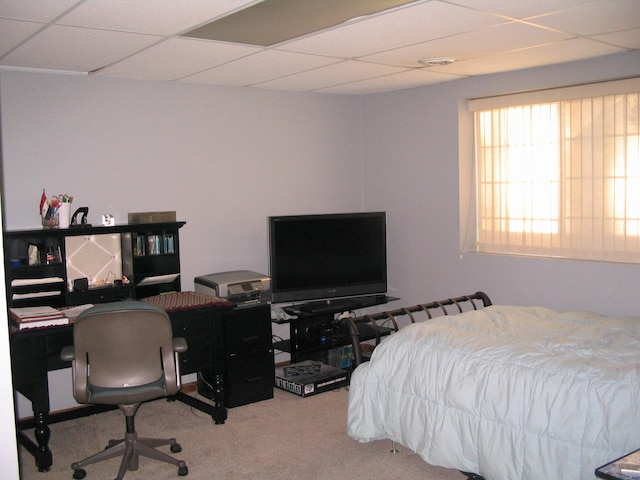 bedroom featuring light carpet and a drop ceiling