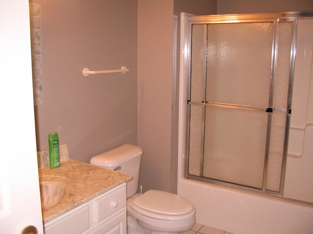 full bathroom featuring tile floors, toilet, bath / shower combo with glass door, and vanity