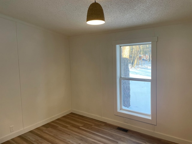 empty room featuring dark hardwood / wood-style floors and a textured ceiling