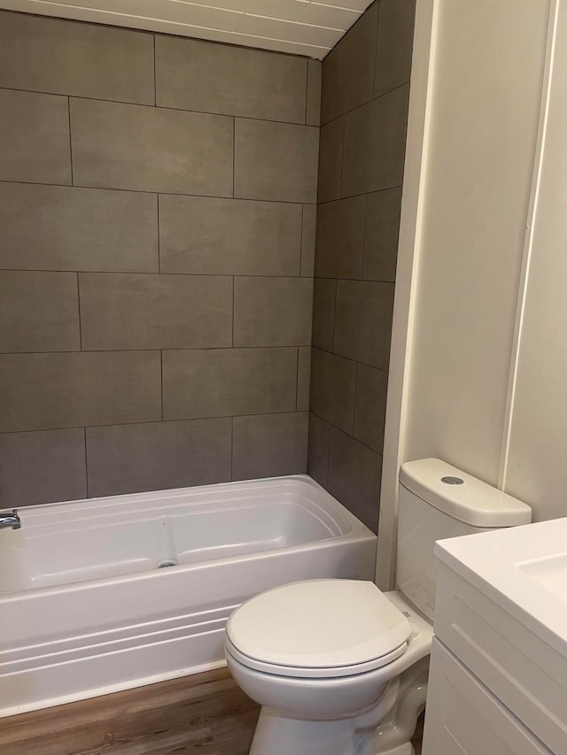 full bathroom with tiled shower / bath, toilet, vanity, and hardwood / wood-style floors