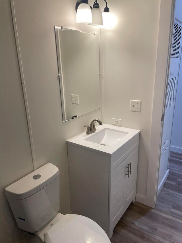 bathroom featuring hardwood / wood-style floors, toilet, and large vanity