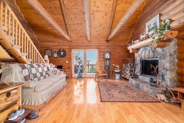 unfurnished living room with high vaulted ceiling, wood ceiling, a stone fireplace, beam ceiling, and hardwood / wood-style flooring