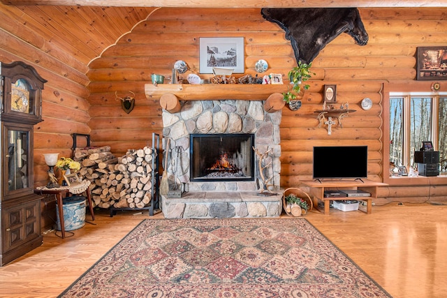 living room featuring a stone fireplace, hardwood / wood-style flooring, wooden ceiling, and log walls