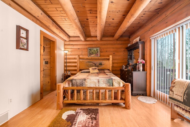 bedroom featuring light hardwood / wood-style flooring, beamed ceiling, log walls, and wood ceiling