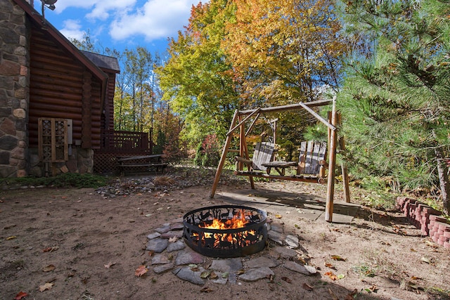 view of yard featuring a deck and an outdoor fire pit