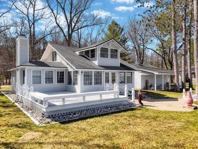 back of house with a wooden deck and a lawn