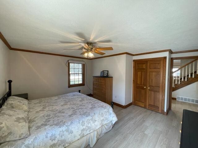 bedroom with ceiling fan, crown molding, and light wood-type flooring