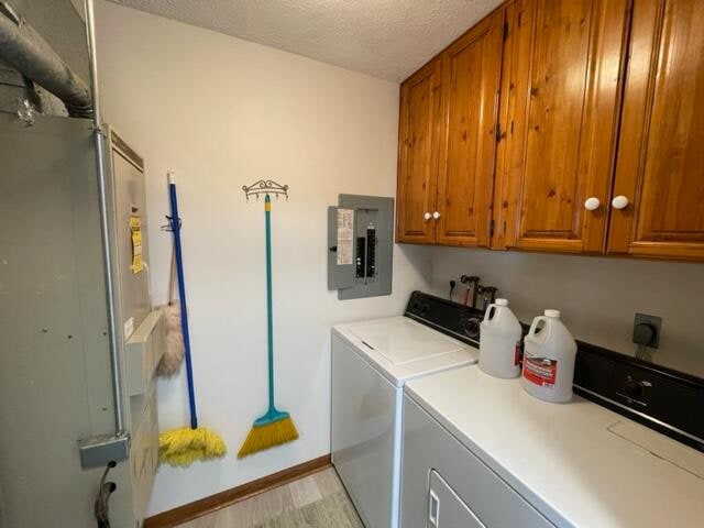 laundry room with cabinets, hookup for an electric dryer, washing machine and dryer, and a textured ceiling