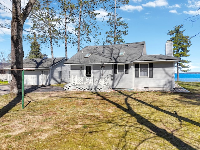 rear view of property featuring a garage and a lawn