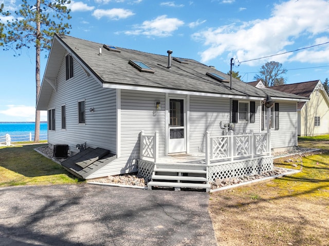 view of front facade featuring a water view and central AC unit