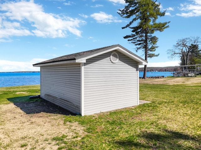 view of outdoor structure with a yard and a water view