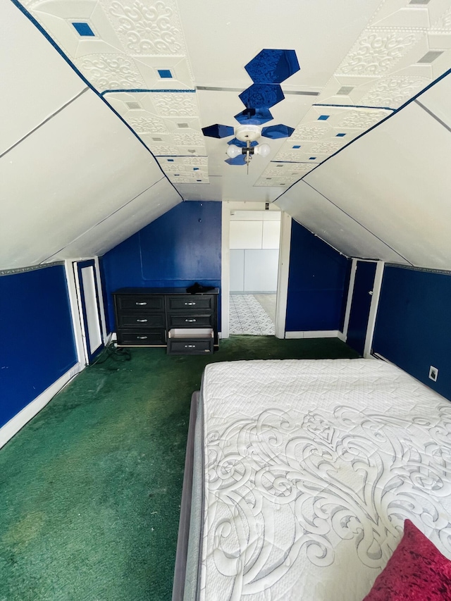 unfurnished bedroom with dark carpet, ceiling fan, and vaulted ceiling