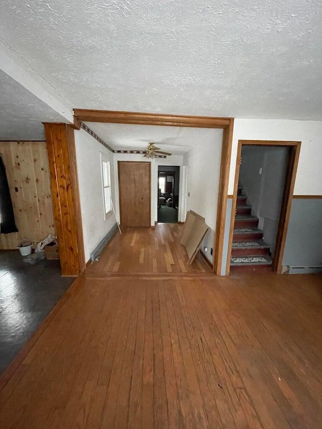 interior space with a textured ceiling, ceiling fan, and hardwood / wood-style floors