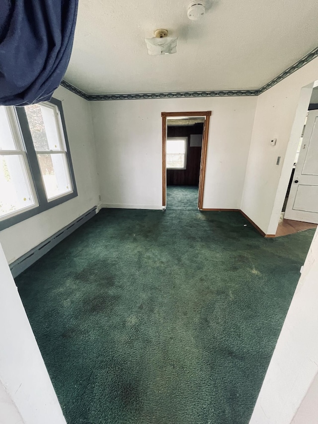 unfurnished bedroom with a textured ceiling and dark carpet