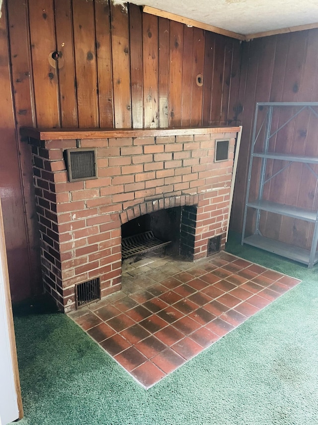 interior details with a brick fireplace, wooden walls, and carpet