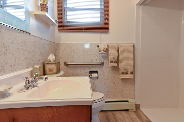 bathroom with toilet, hardwood / wood-style floors, vanity, and baseboard heating