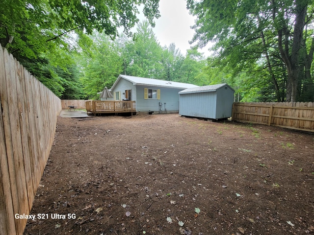 view of yard featuring a storage unit and a wooden deck