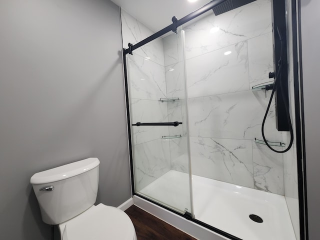 bathroom featuring a shower with shower door, toilet, and hardwood / wood-style floors