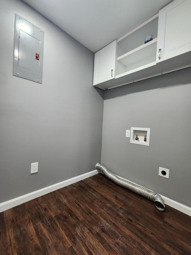 washroom with electric panel, hardwood / wood-style flooring, electric dryer hookup, and cabinets