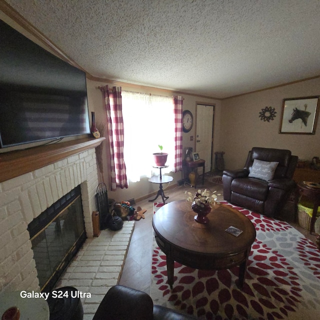 living room featuring ornamental molding, a brick fireplace, and a textured ceiling