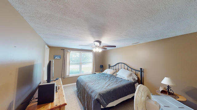 carpeted bedroom featuring a textured ceiling and ceiling fan