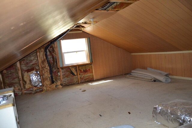 additional living space featuring lofted ceiling, wood walls, and water heater