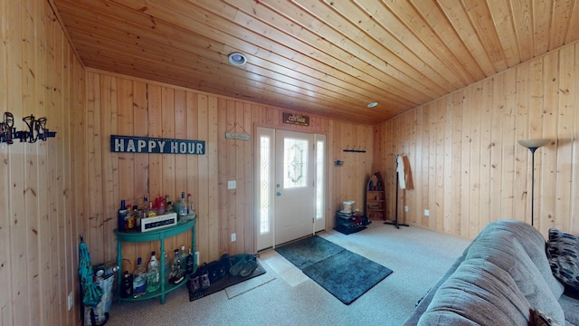 carpeted foyer entrance with wood walls and wood ceiling