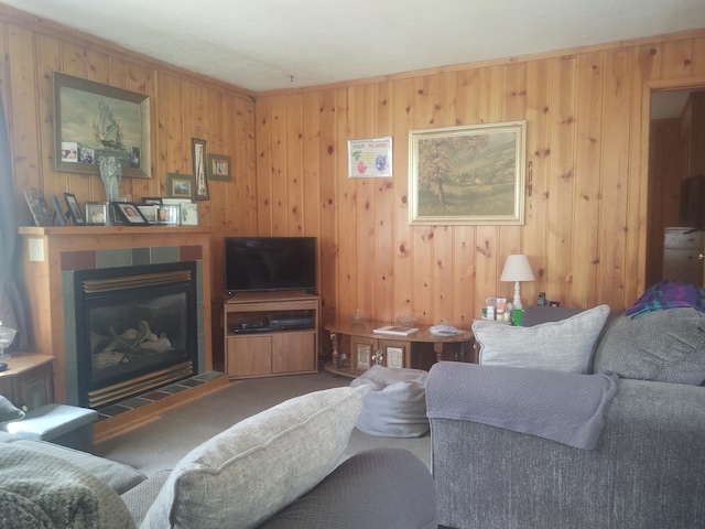 carpeted living room featuring wood walls and a fireplace