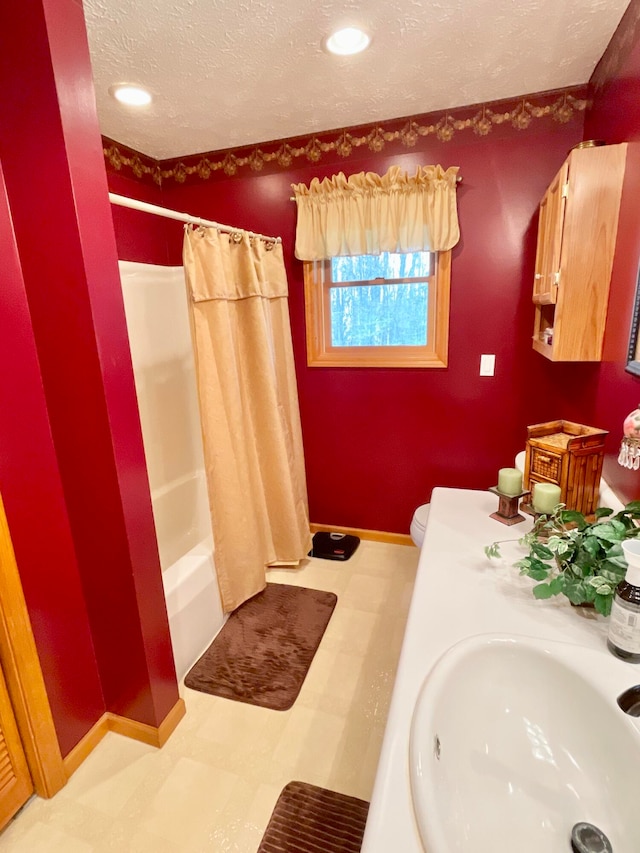 full bathroom with toilet, tile flooring, shower / bath combination with curtain, sink, and a textured ceiling