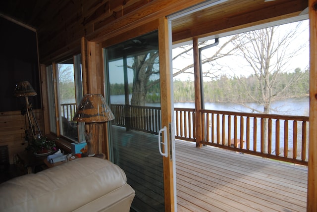 sunroom featuring a water view