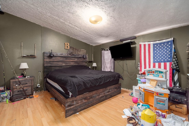 bedroom with hardwood / wood-style flooring and a textured ceiling