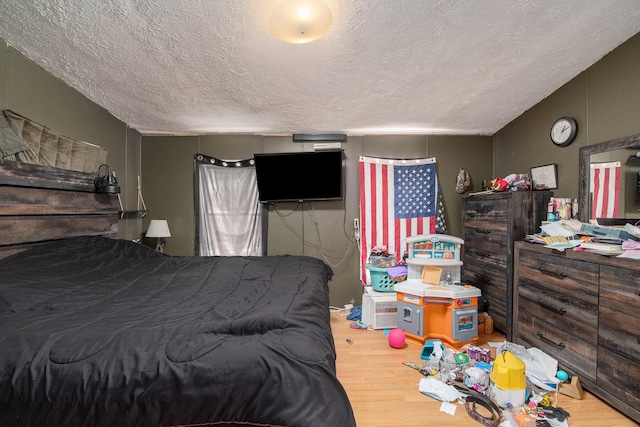 bedroom featuring a textured ceiling and light wood-type flooring