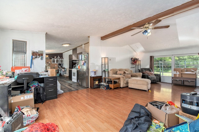 living room featuring ceiling fan, lofted ceiling with beams, light hardwood / wood-style floors, and a textured ceiling