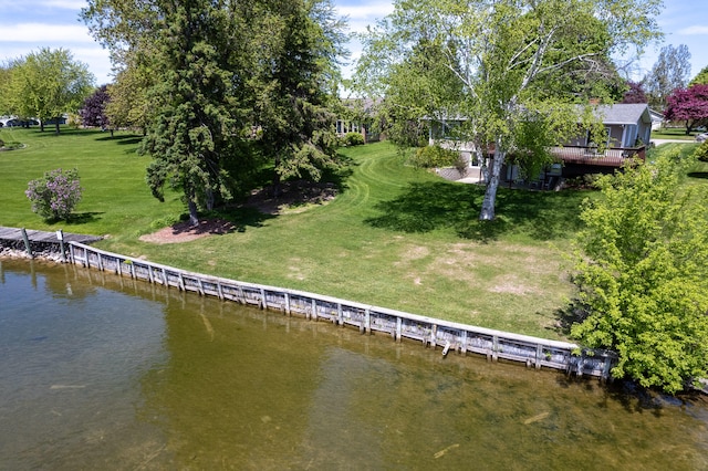 view of dock featuring a lawn and a water view